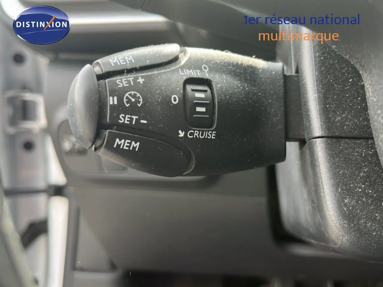 Gros plan sur la commande de régulateur de vitesse noire dans l’habitacle d’une Citroën C3 blanche de 2018.