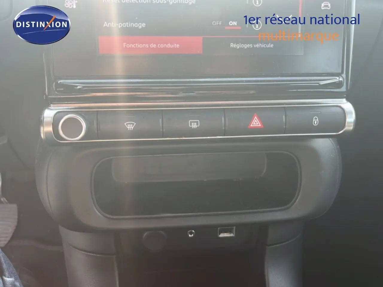 Vue rapprochée de la console centrale noire du Citroën C3 blanc, avec commandes de climatisation et écran tactile.