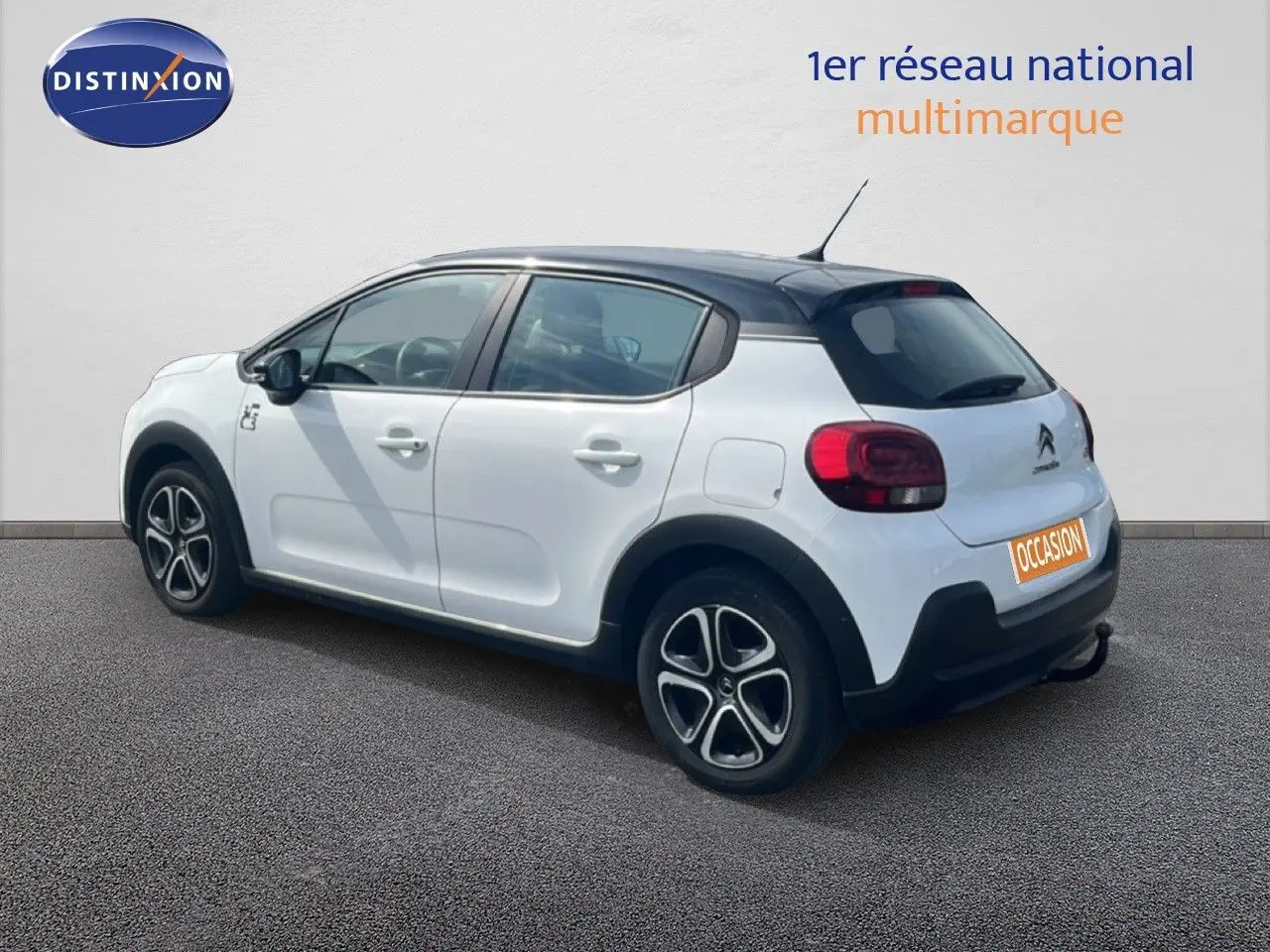Citroën C3 blanc vue 3/4 arrière côté droit, toit noir et jantes alliage distinctives.