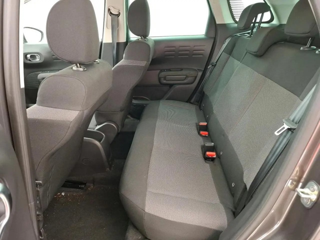 Vue intérieure côté arrière droit du Citroën C3 Aircross 2023 gris foncé, montrant la banquette arrière en tissu gris.