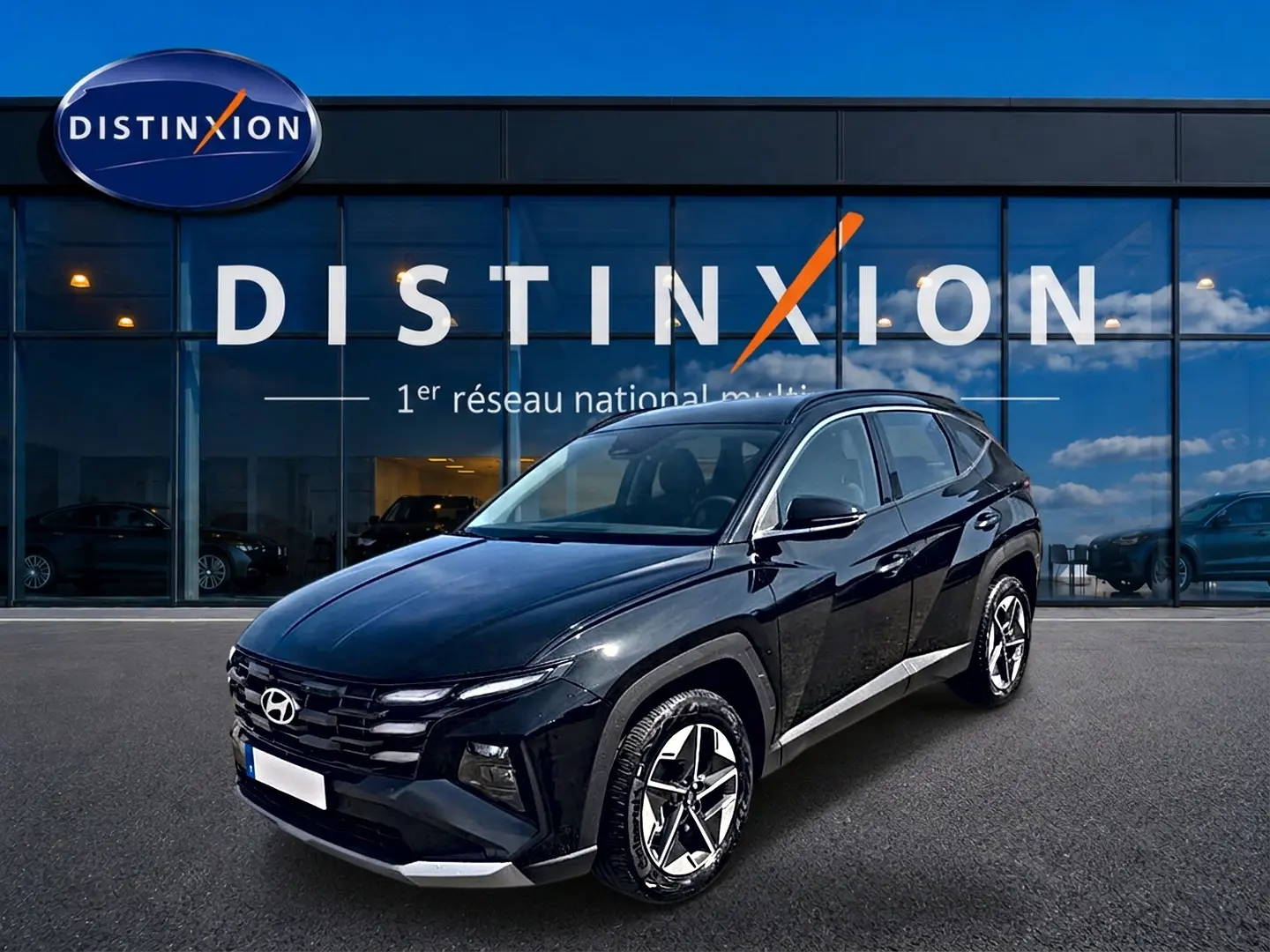 Hyundai Tucson 2026 noir en 3/4 avant droit, avec jantes alliage et calandre distinctive devant showroom Distinxion.