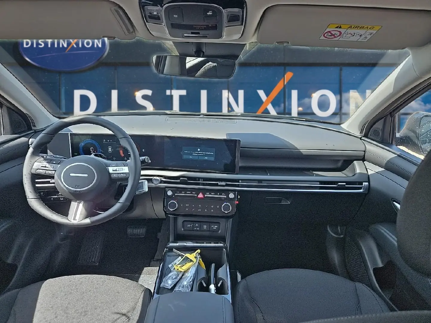 Vue intérieure avant du Hyundai Tucson 2026 noir, montrant tableau de bord moderne et volant multifonction cuir.