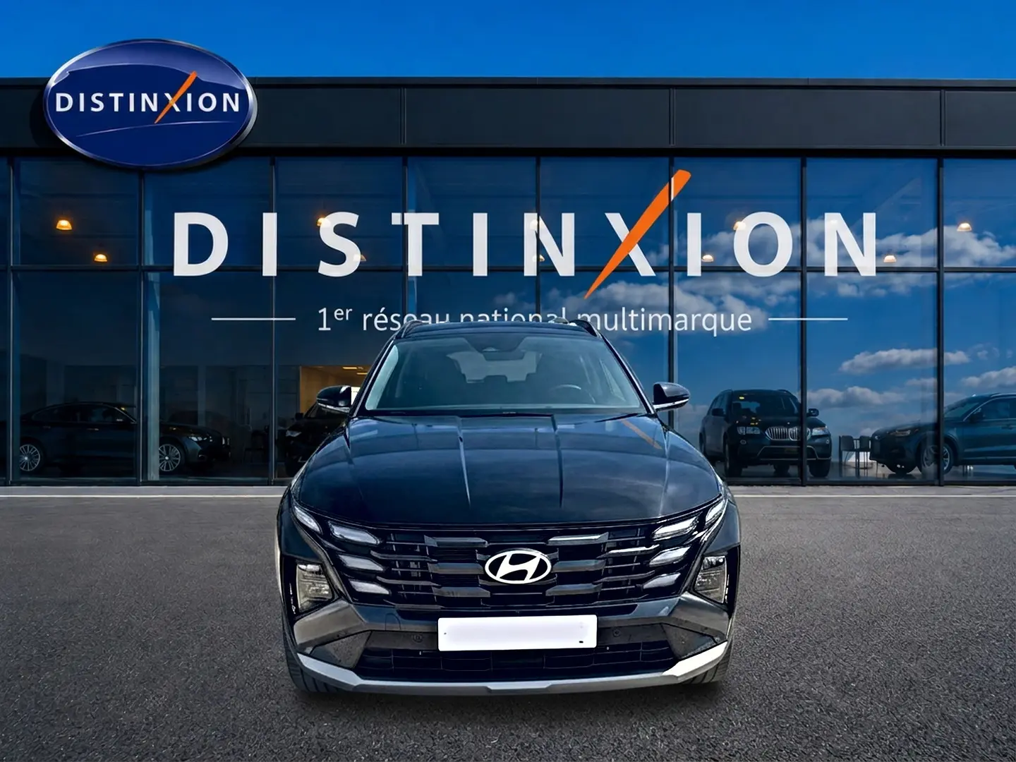 Vue frontale d'un Hyundai Tucson noir 2026 hybride essence, avec calandre distinctive et phares LED intégrés.