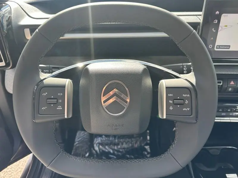Vue rapprochée du volant multifonction noir avec logo Citroën argenté au centre du Citroën C3 Aircross 2026.