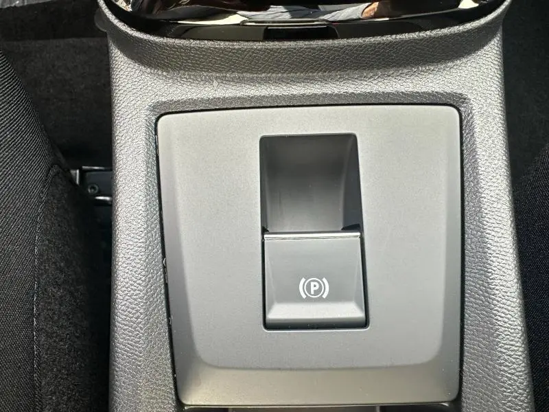 Gros plan sur le bouton de frein à main électronique dans l'habitacle du Citroën C3 Aircross gris Mercury.
