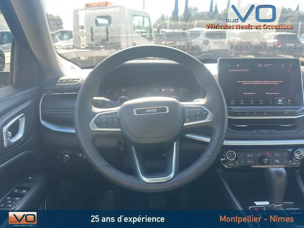Vue intérieure centrée sur le volant Jeep Compass 2023 avec écran tactile et commandes au volant visibles
