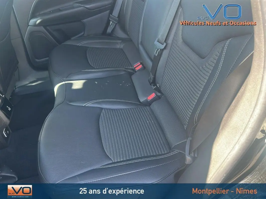 Vue rapprochée des sièges arrière noirs du Jeep Compass 2023, mettant en valeur la finition cuir et les ceintures de sécurité.