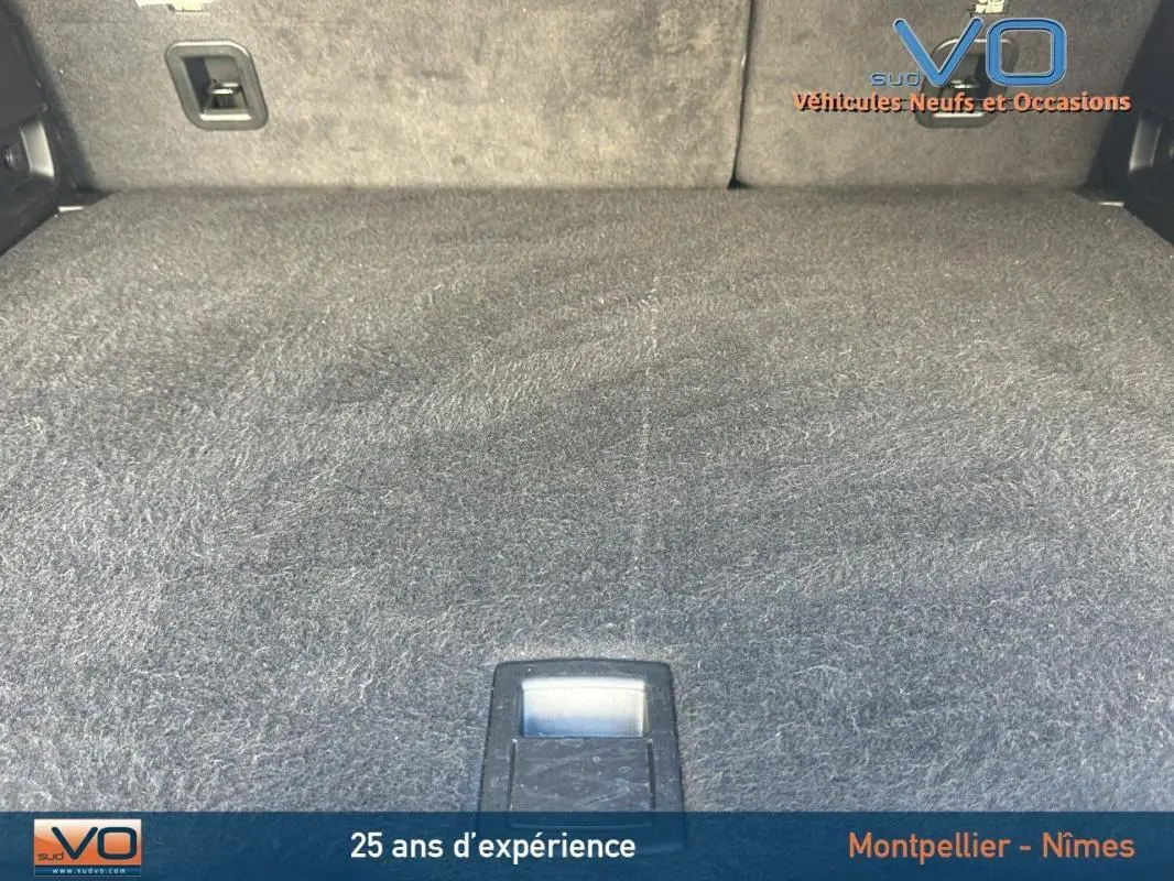 Espace de coffre du Jeep Compass noir 2023, montrant le tapis de sol et les fixations internes du coffre.