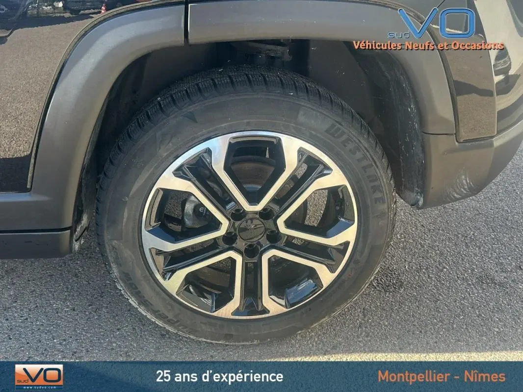 Gros plan sur la jante 18 pouces noire et argentée du Jeep Compass noir, côté avant droit.