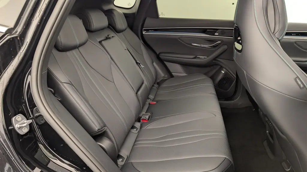 Vue intérieure côté gauche des sièges arrière noirs en similicuir vegan du BYD SEAL U 2025 avec surpiqûres bleues.