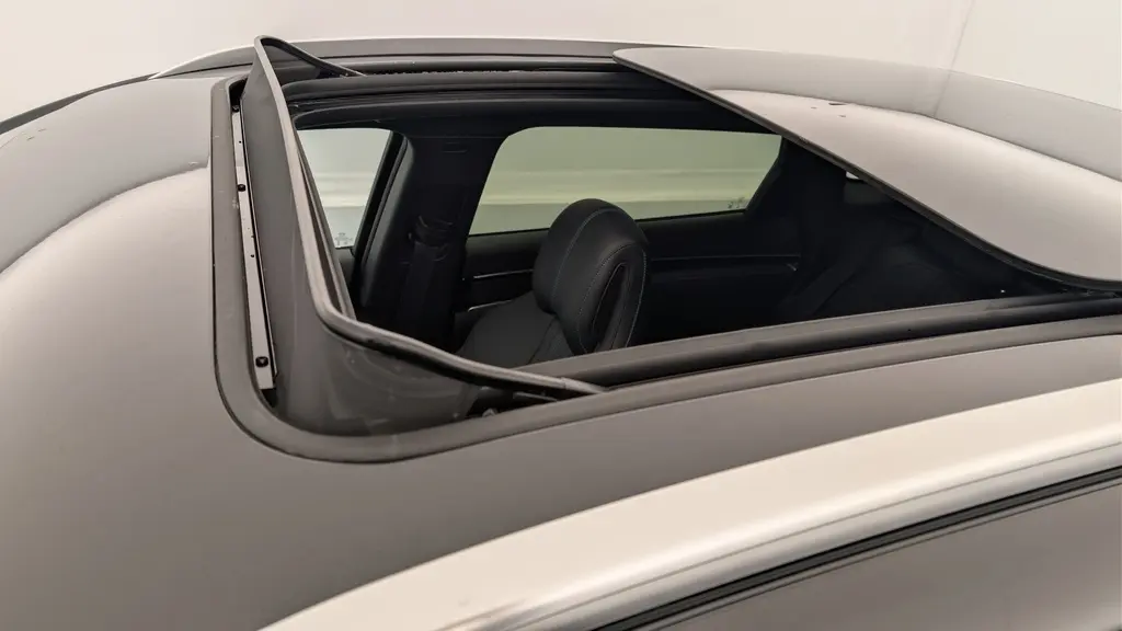 Vue rapprochée du toit ouvrant panoramique ouvert du BYD SEAL U noir obsidienne, montrant l'intérieur et le siège avant.