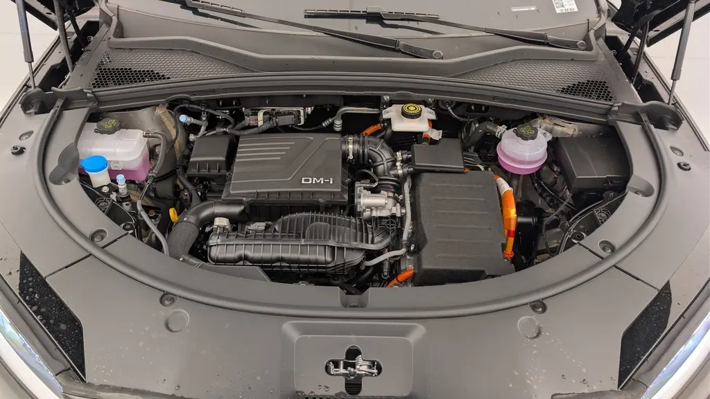 Vue rapprochée du compartiment moteur du BYD SEAL U hybride rechargeable en Obsidian Black, avec capot ouvert.