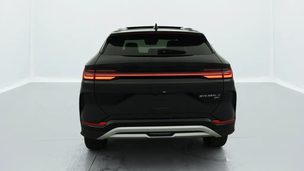 Vue arrière d’un BYD SEAL U hybride rechargeable Obsidian Black avec feux arrière LED allumés et hayon fermé.