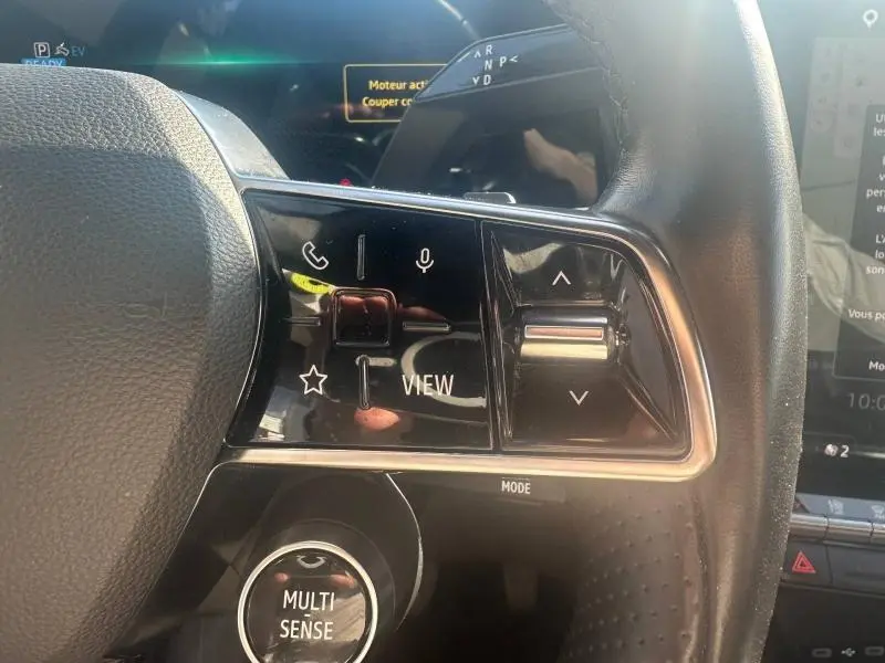 Gros plan sur les commandes au volant du Renault Espace 2024 gris schiste, avec boutons multifonctions et molette Multi-Sense.