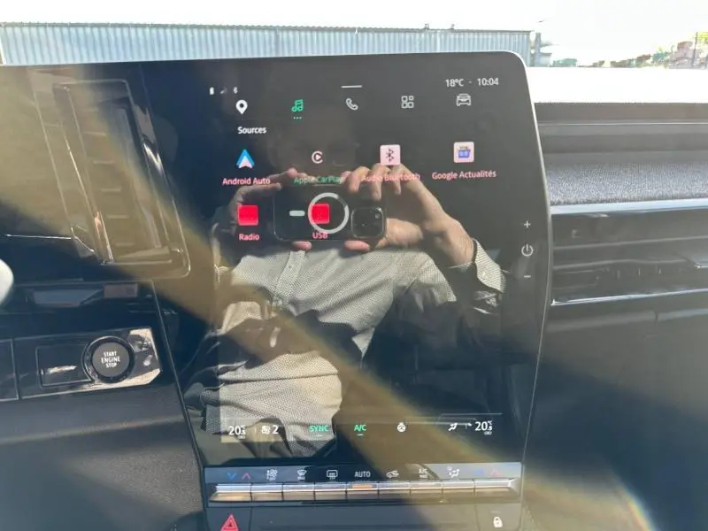Vue intérieure centrée sur l'écran tactile du tableau de bord du Renault Espace 2024 gris schiste, avec commandes visibles.