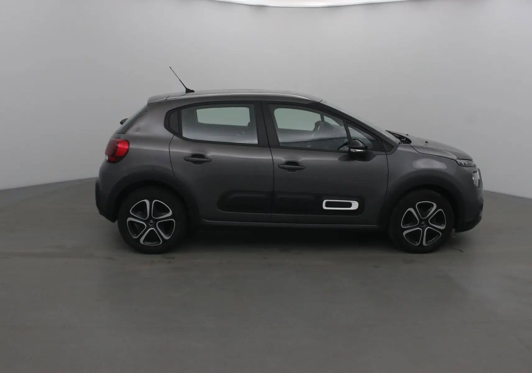 Citroën C3 gris platinium vue de profil côté gauche, avec protections latérales noires et jantes spécifiques.