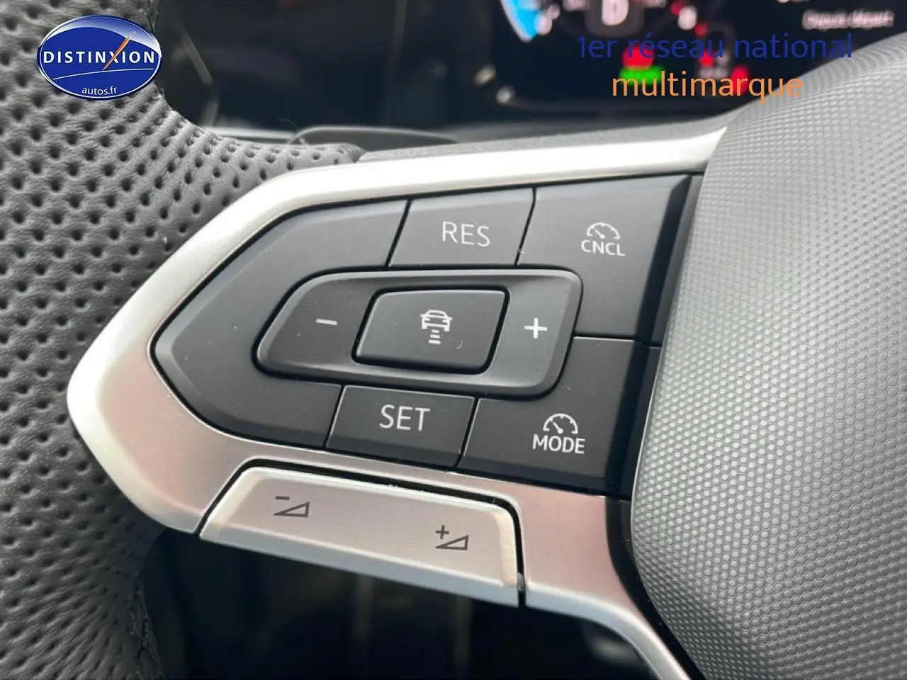 Gros plan sur les commandes multifonctions à gauche du volant cuir perforé d’une Volkswagen Golf noire 2026.