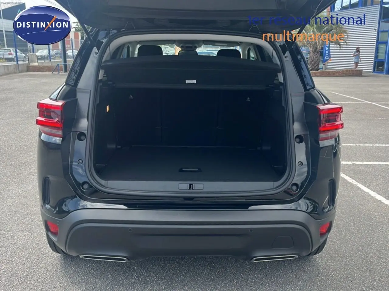 Vue arrière du Citroën C5 Aircross noir métal 2025 avec coffre ouvert et feux arrière allumés.