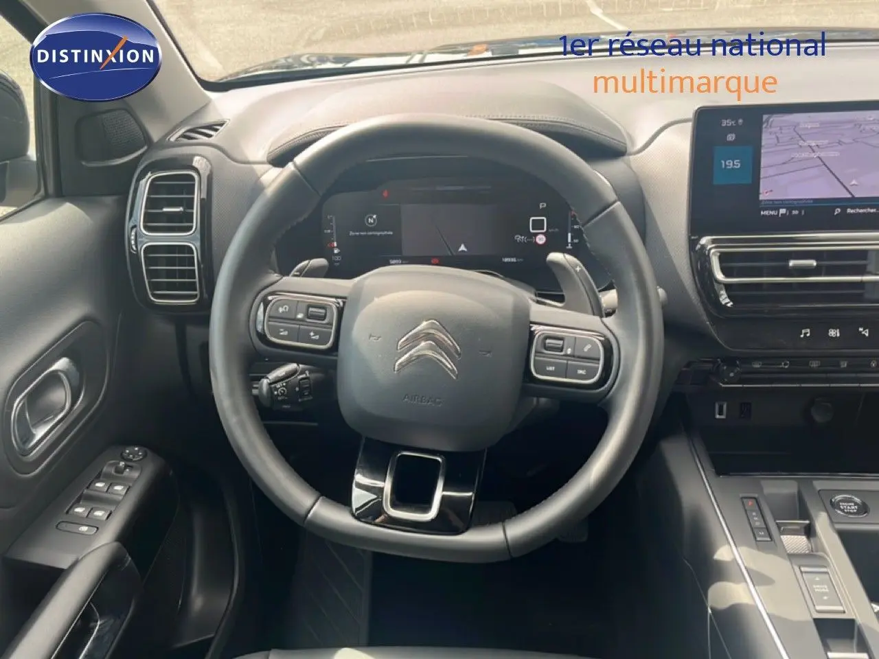 Vue intérieure centrée sur le volant et le tableau de bord du Citroën C5 Aircross noir métal, avec écran tactile et commandes intégrées.