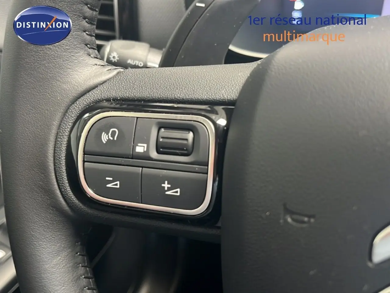 Gros plan sur les commandes gauche du volant noir du Citroën C5 Aircross 2025 hybride, avec boutons de volume et appel.
