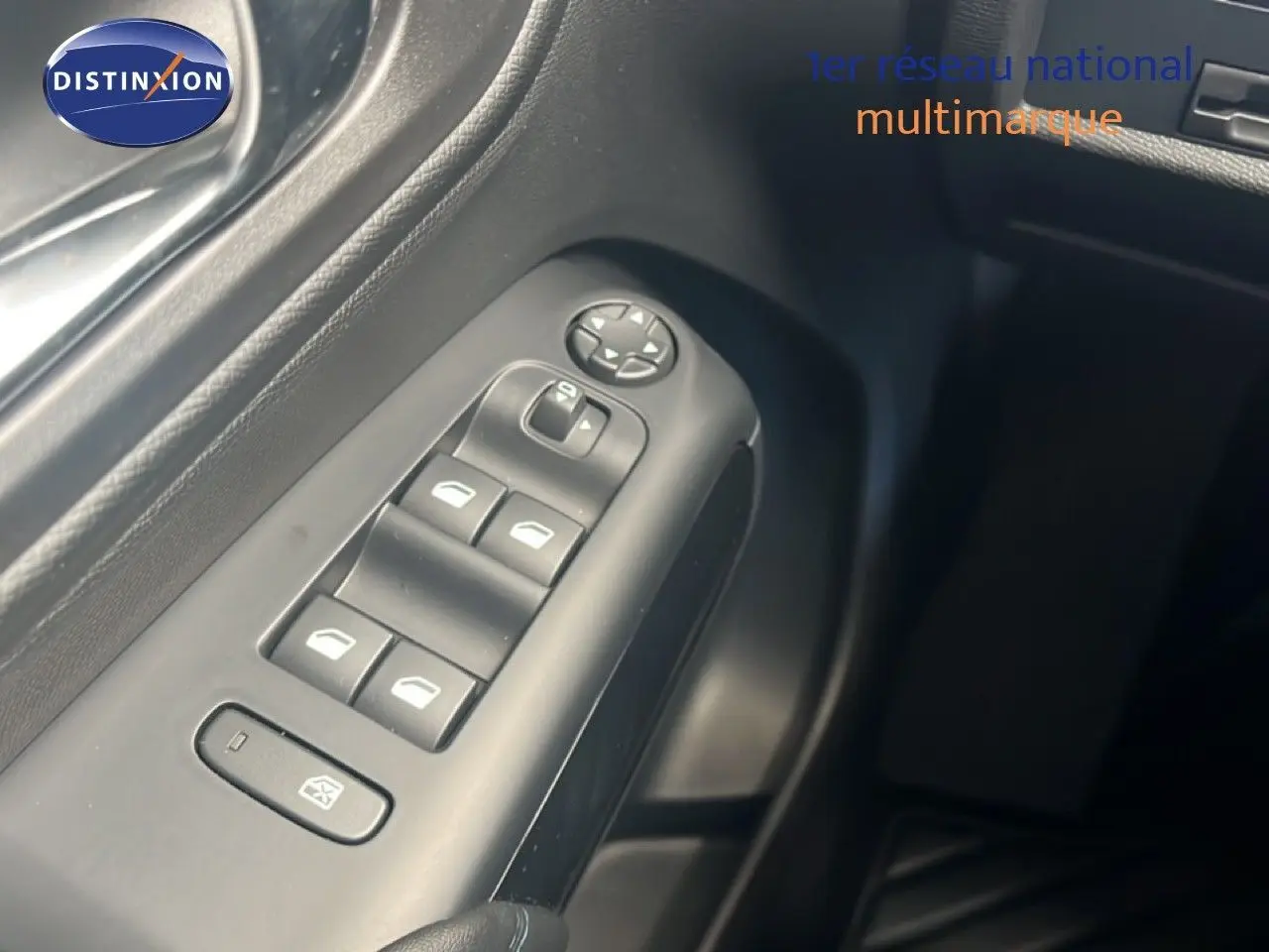 Gros plan sur les commandes des vitres électriques côté gauche de la porte d’un Citroën C5 Aircross noir métal 2025.