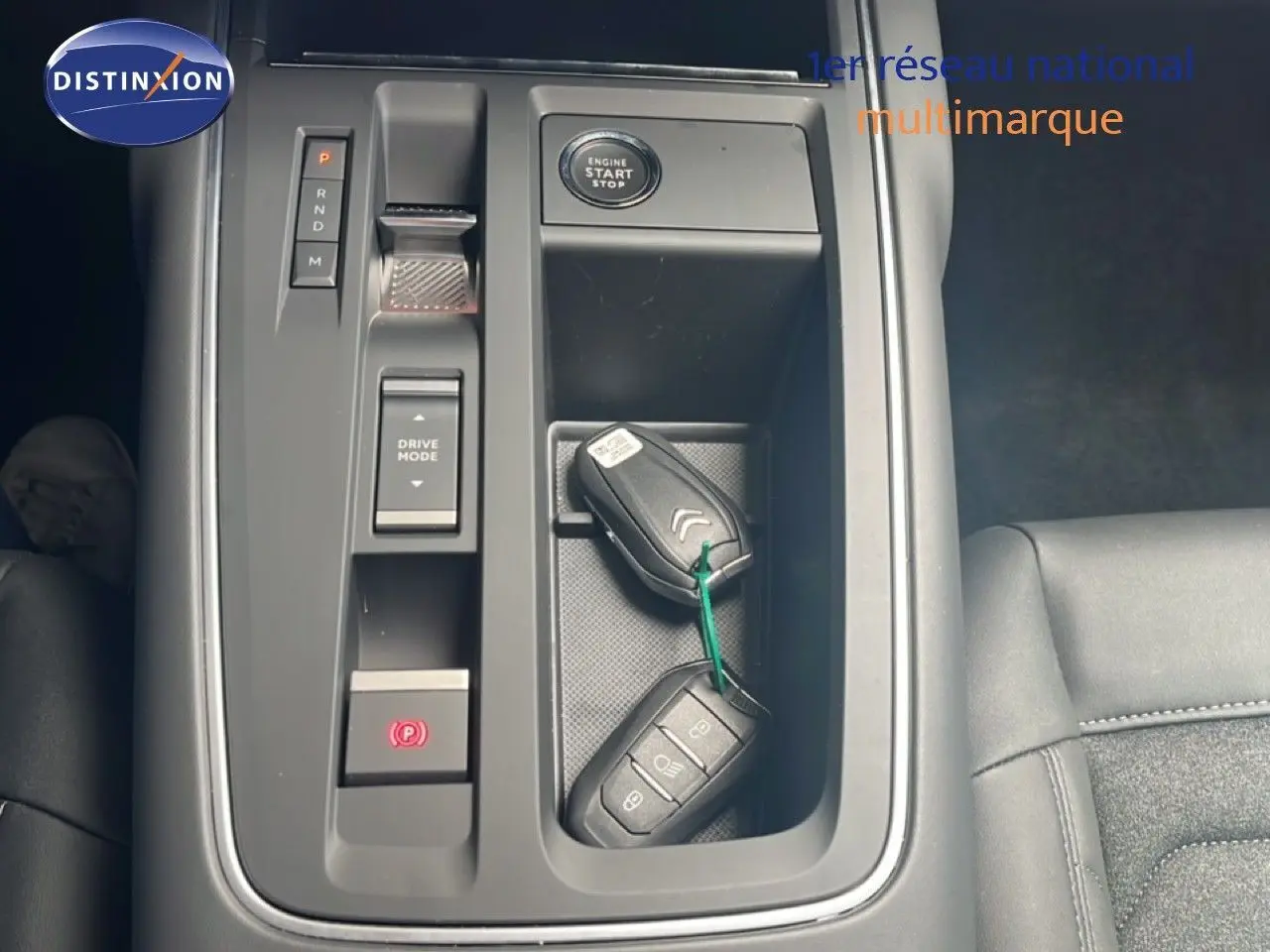 Vue rapprochée de la console centrale noire du Citroën C5 Aircross 2025 avec clés, bouton start et commandes de boîte auto.