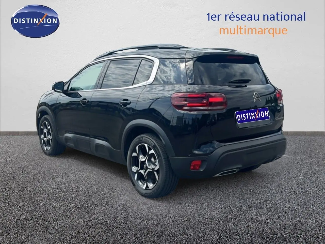 Vue 3/4 arrière droite du SUV Citroën C5 Aircross noir métal, soulignant ses jantes distinctives et ses feux arrière LED.