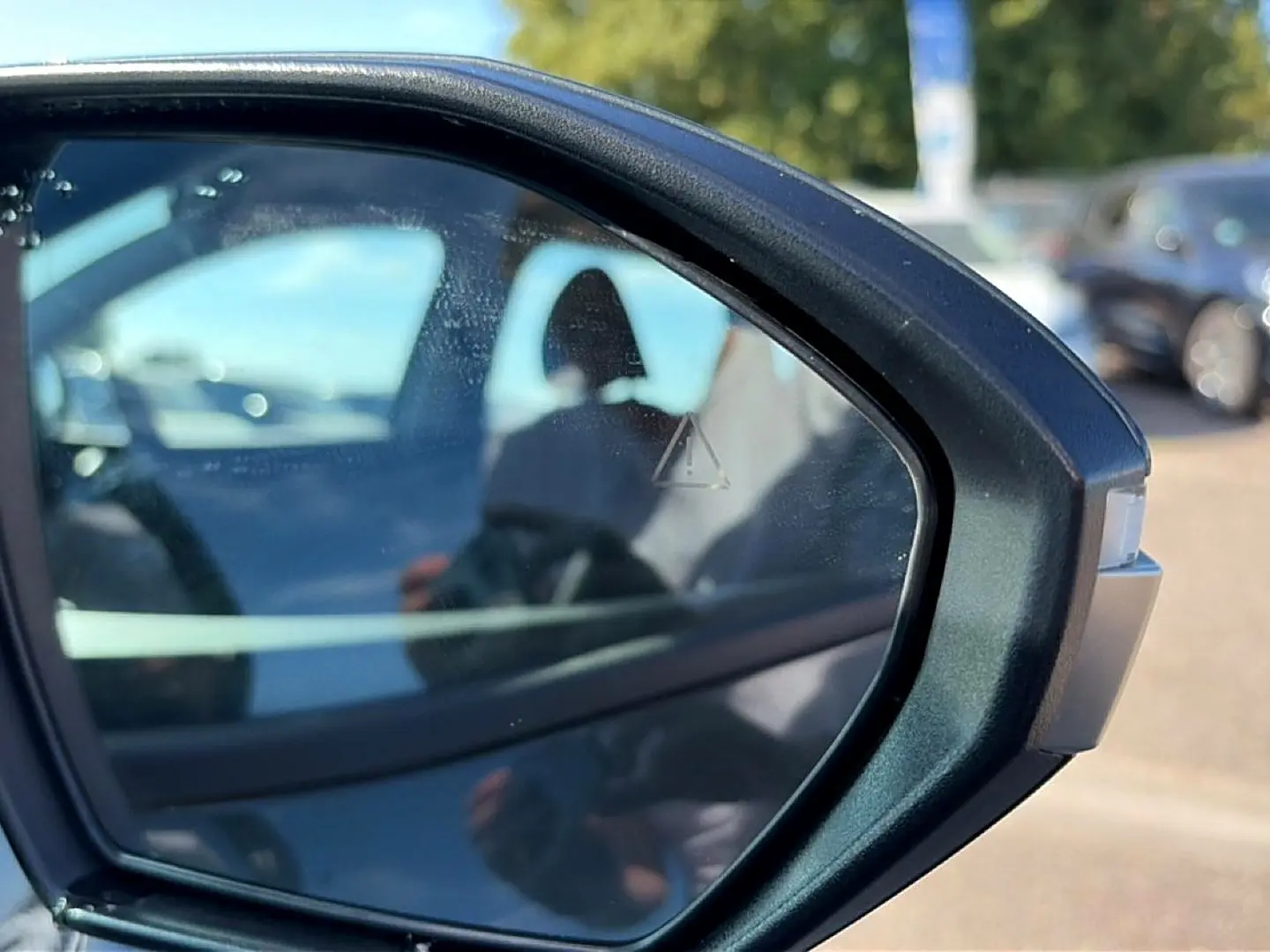 Rétroviseur extérieur droit du Hyundai Tucson vert hybride 2026 avec alerte d’angle mort visible.