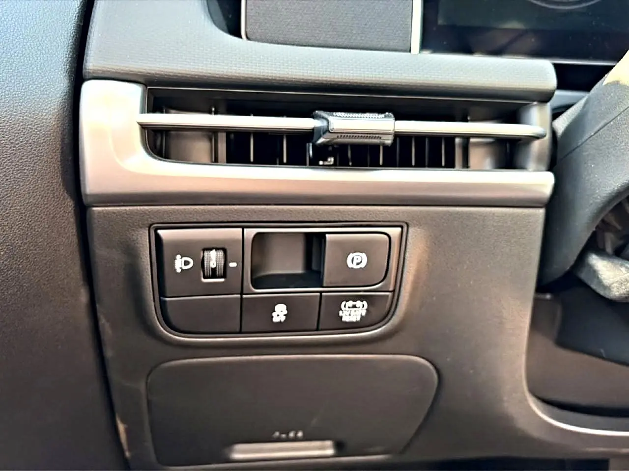 Détail intérieur côté conducteur du Hyundai Tucson 2026, montrant les commandes d’éclairage et de frein à main électronique.