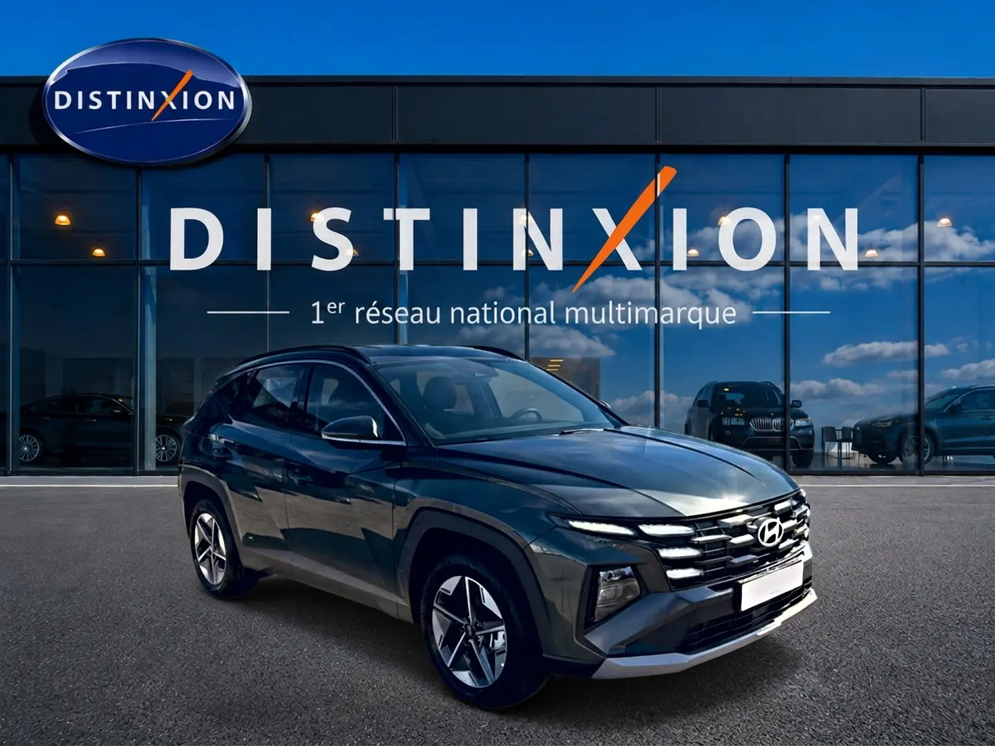 Hyundai Tucson hybride vert vue 3/4 avant droit devant showroom Distinxion avec jantes alu 18 pouces.