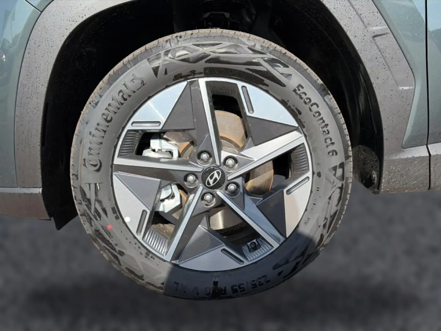 Gros plan sur la roue avant droite du Hyundai Tucson vert 2026 avec jante alu au design moderne et logo Hyundai central.
