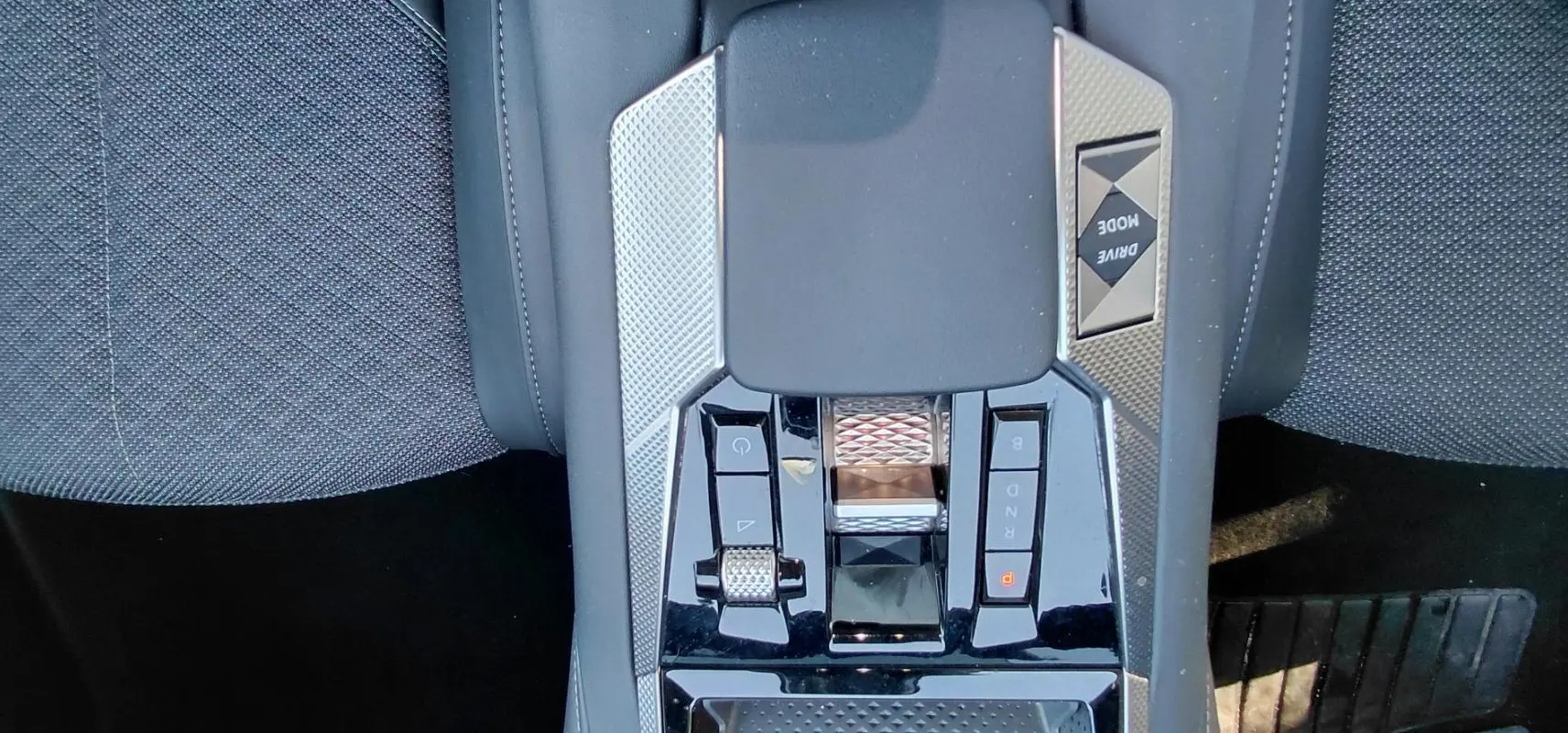 Vue rapprochée de la console centrale du DS4 2024 hybride gris, avec commandes de boîte automatique et bouton Drive Mode.