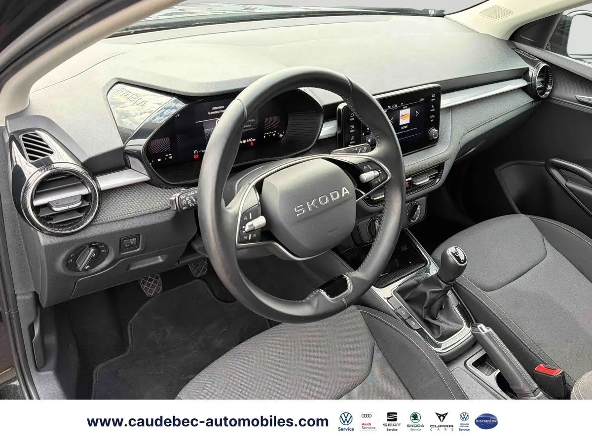 Vue intérieure côté conducteur de la Skoda Fabia 2025 noire, volant cuir 2 branches et tableau de bord digital.