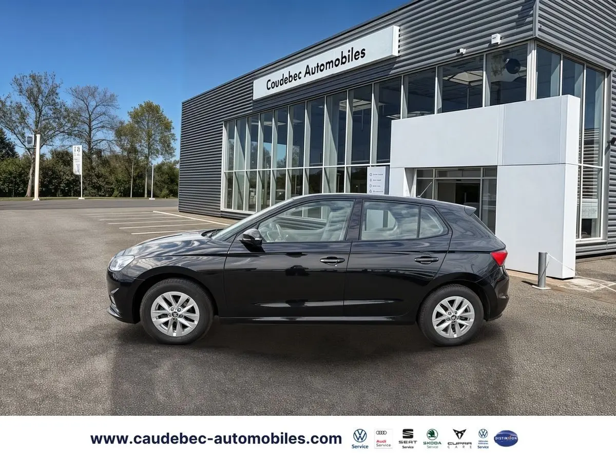 Vue de profil côté gauche d'une Skoda Fabia noire 2025 garée devant un showroom moderne.