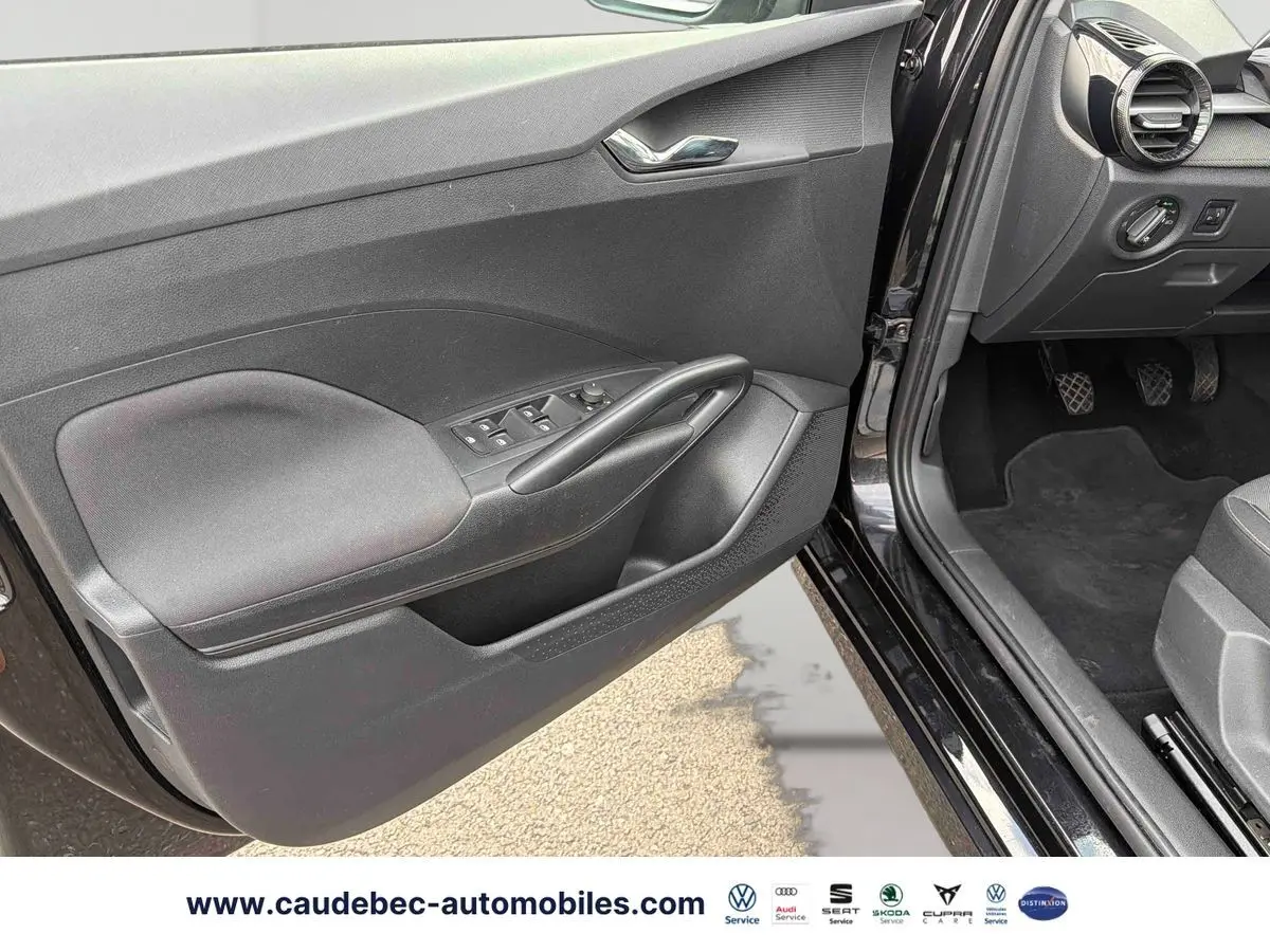 Vue intérieure côté conducteur de la porte noire ouverte d’une Skoda Fabia 2025 avec commandes de vitres et rétroviseurs.