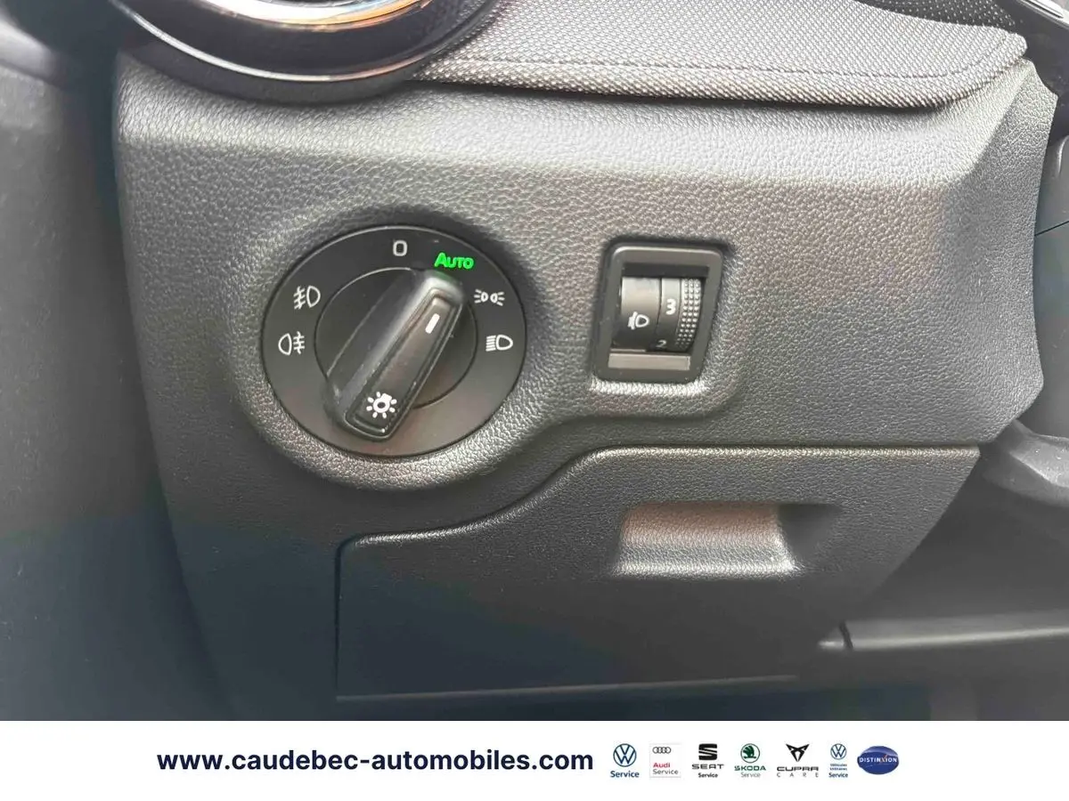 Gros plan sur le panneau de commande des phares noirs à gauche du tableau de bord d'une Skoda Fabia 2025.