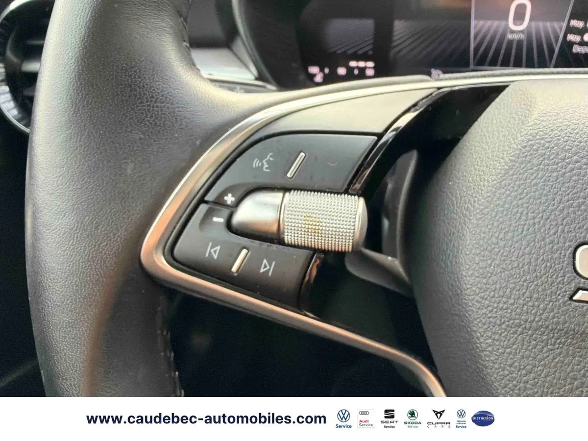 Gros plan sur le volant cuir noir multifonctions de la Skoda Fabia 2025 avec molette métallique et commandes audio.