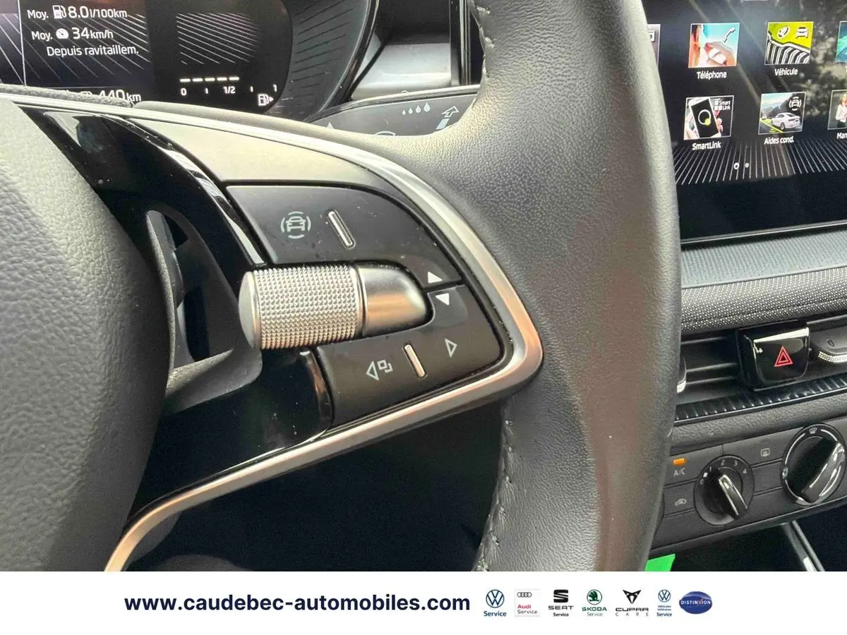 Gros plan sur le volant cuir noir multifonctions et la partie centrale de la planche de bord avec écran tactile de la Skoda Fabia 2025.