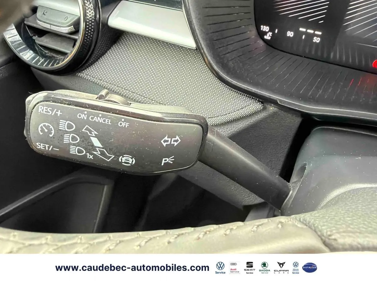 Gros plan sur la commande multifonction du volant cuir noir de la Skoda Fabia 2025, tableau de bord partiellement visible.
