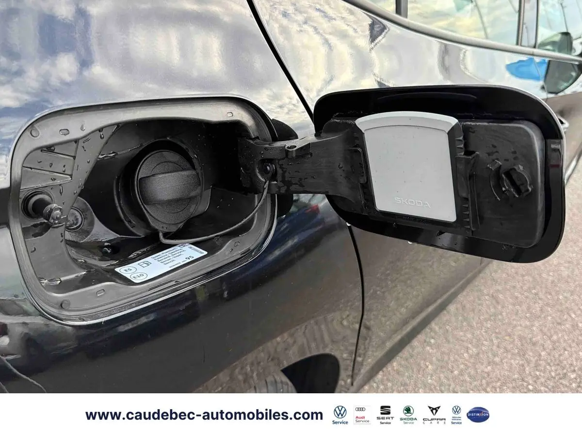 Trappe à carburant ouverte côté gauche d'une Skoda Fabia noire 2025, avec bouchon essence visible.