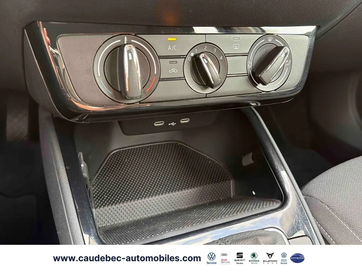 Vue rapprochée des commandes de climatisation manuelle et des ports USB-C sur la console centrale noire d'une Skoda Fabia.