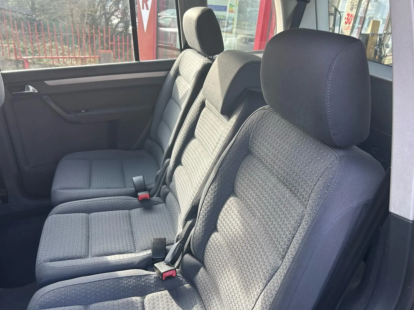 Vue intérieure des sièges arrière gris du Volkswagen Touran 1.9 TDI 2004, montrant les appuie-têtes et ceintures de sécurité.