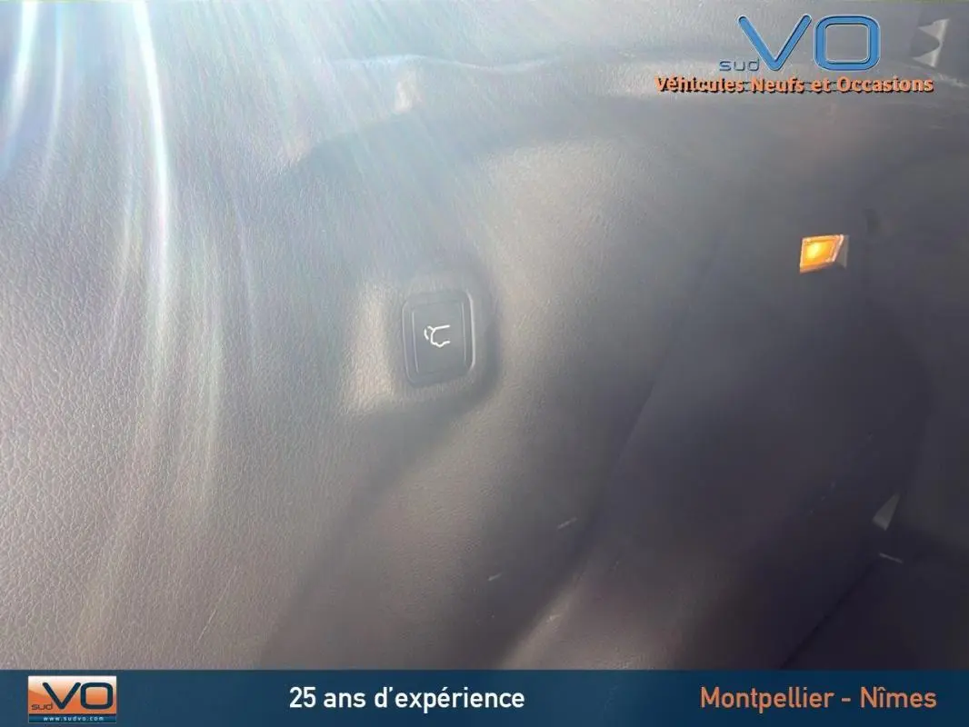 Bouton d'ouverture du coffre sur la garniture intérieure arrière d'un Jeep Compass gris 2023.