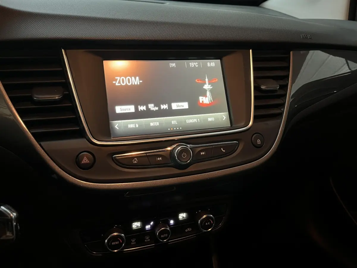 Tableau de bord intérieur de l’Opel Crossland X 2021 avec écran tactile central allumé et commandes de climatisation digitales.