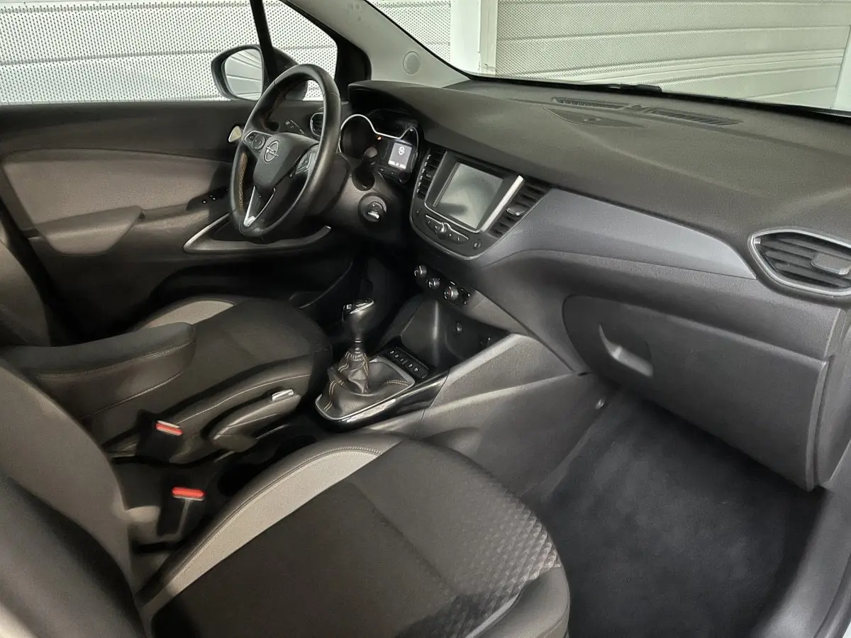 Vue intérieure côté passager de l’Opel Crossland X 1.2 Turbo 2021, tableau de bord noir avec écran tactile central.