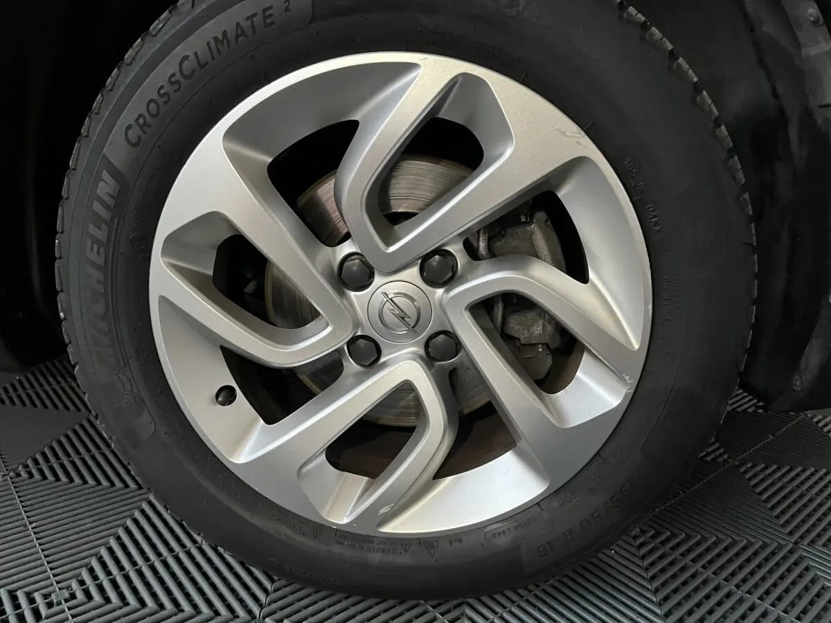 Gros plan sur la jante alliage argentée avec logo Opel au centre, montée sur pneu Michelin CrossClimate.