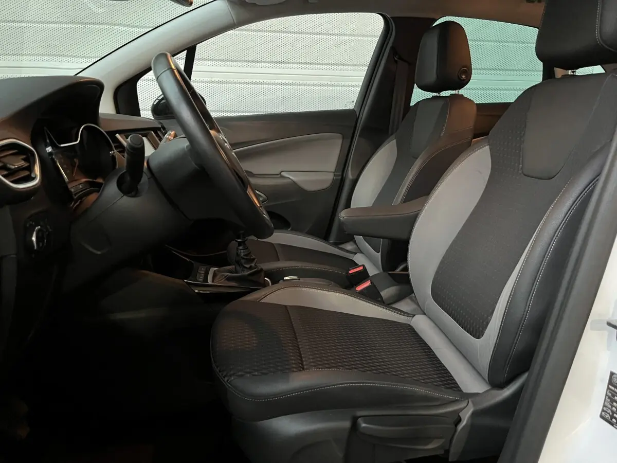 Vue intérieure côté conducteur de l'Opel Crossland X 2021, sièges bi-ton noirs et gris avec volant cuir multifonctions.