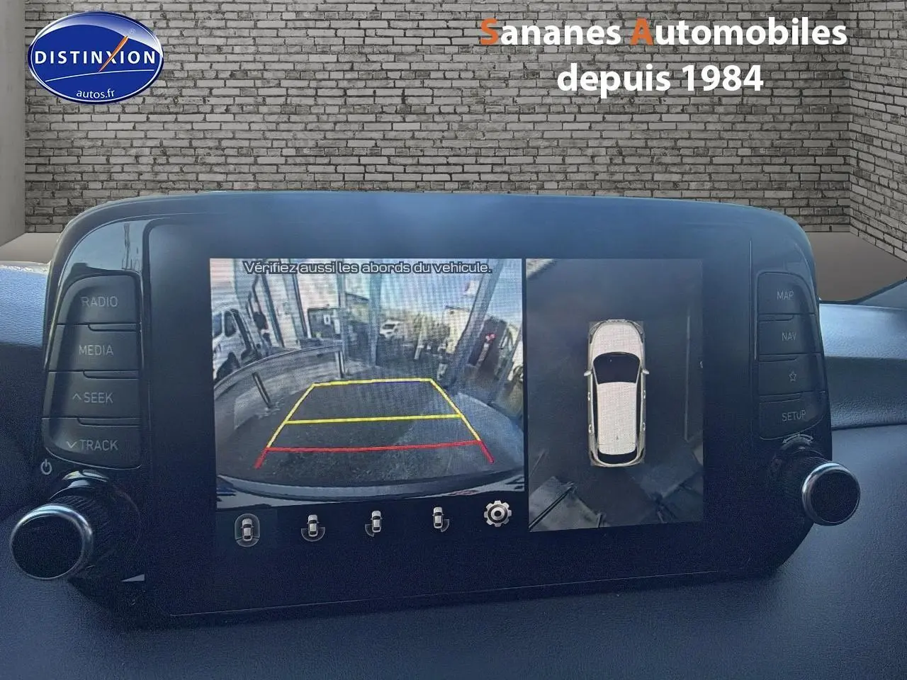 Vue intérieure sur l’écran tactile du Hyundai Tucson gris foncé montrant la caméra 360 et l’aide au stationnement arrière.