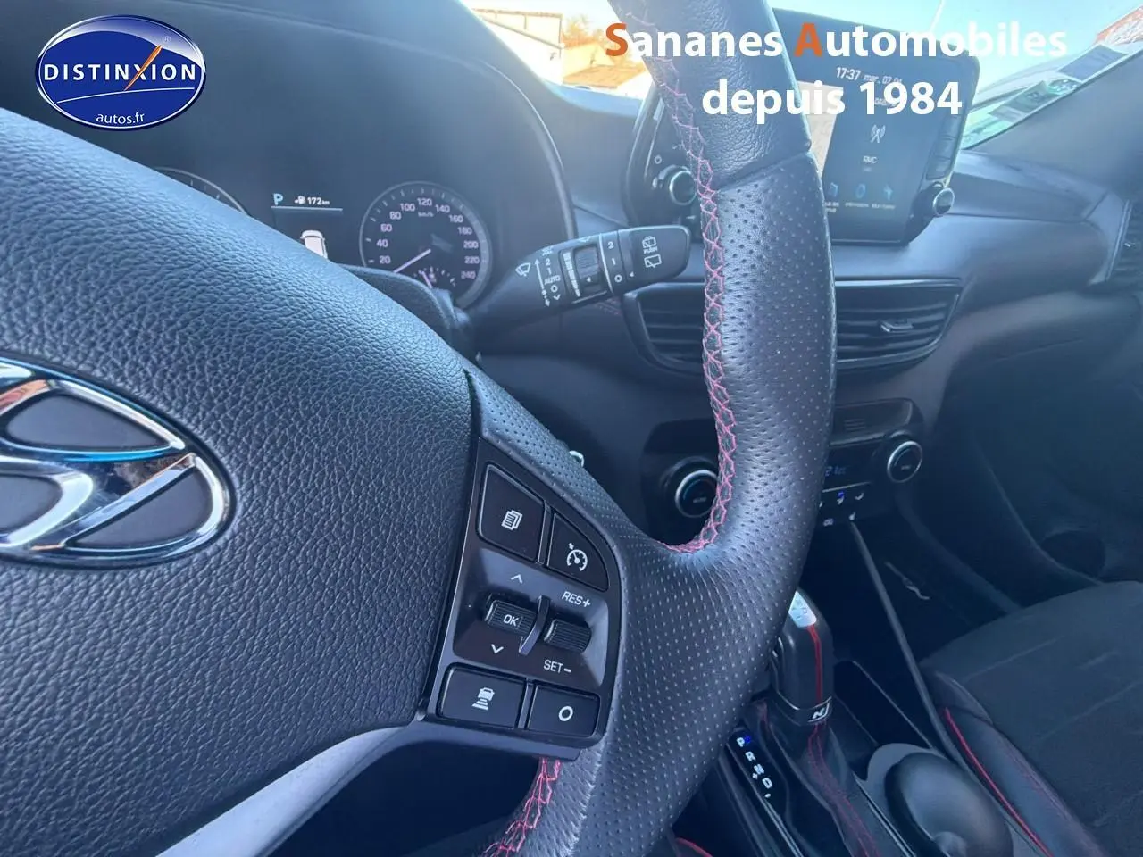 Vue intérieure centrée sur le volant cuir perforé avec surpiqûres rouges et tableau de bord du Hyundai Tucson N Line 2020.