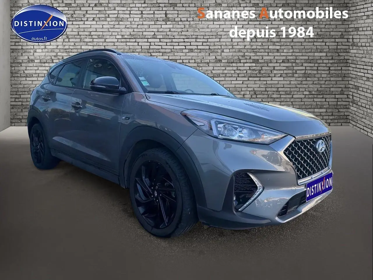 Vue 3/4 avant gauche d'un Hyundai Tucson 1.6 Hybrid 136 N Line gris foncé avec jantes alliage noires.